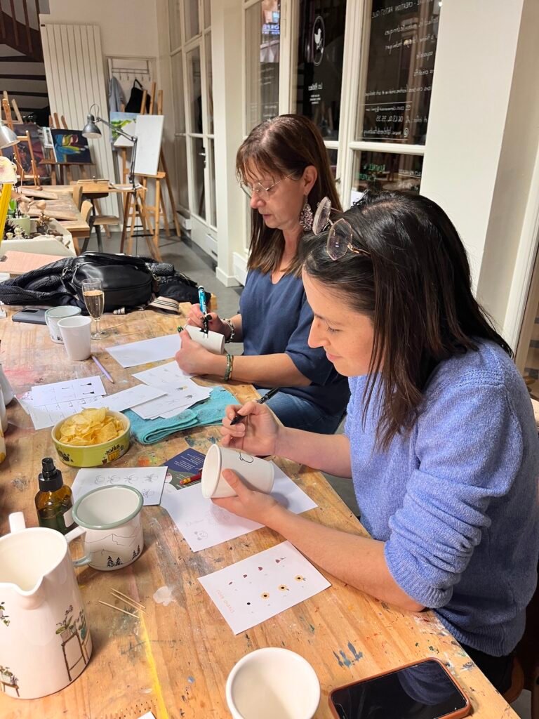 Deux dames, une mère et sa fille, sont entrain de peindre une tasse en porcelaine